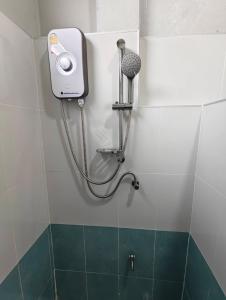um chuveiro na casa de banho com secador de cabelo em ลีลาโคซี่ รีสอร์ท ณ สิชล em Sichon