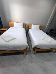 two beds sitting next to each other in a room at ลีลาโคซี่ รีสอร์ท ณ สิชล in Sichon