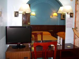 a television sitting on a desk with a bed at Hostal Centro Sol Madrid in Madrid