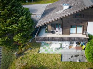 einen Blick über ein Haus mit einer Terrasse und Stühlen in der Unterkunft Casa Anita in Laax-Murschetg