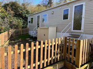 una casa con una valla de madera delante de ella en Beauport Holiday Park en Hastings