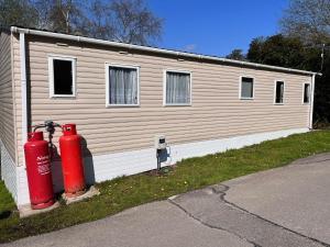 un edificio con una boca de incendios roja delante de él en Beauport Holiday Park en Hastings