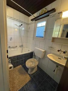 ein Badezimmer mit einem WC, einer Badewanne und einem Waschbecken in der Unterkunft Casa Anita in Laax-Murschetg