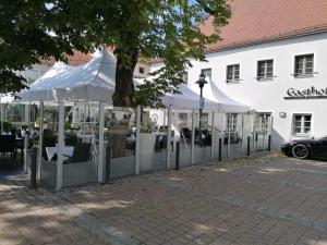 un grupo de tiendas blancas frente a un edificio en Hotel Restaurant Zum Wendelwirt, en Germaringen