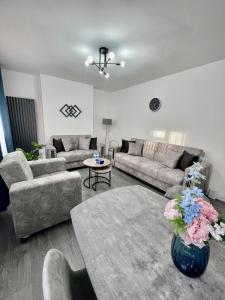 ein Wohnzimmer mit einem Sofa und einem Tisch in der Unterkunft Deluxe Apartment - Next to Kings Cross - Eurostar & Euston Station in London