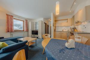 ein Wohnzimmer mit einem blauen Sofa und einem Tisch in der Unterkunft Haus Platina in Sankt Gallenkirch