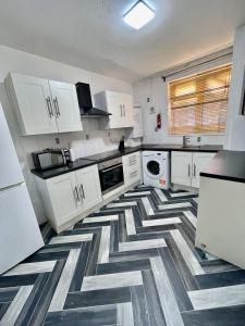 uma cozinha com armários brancos e um piso geométrico em Deluxe Apartment - Next to Kings Cross - Eurostar & Euston Station em Londres