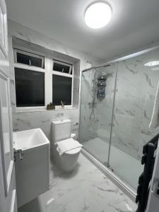 uma casa de banho branca com um WC e um chuveiro em Deluxe Apartment - Next to Kings Cross - Eurostar & Euston Station em Londres