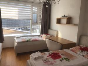 Habitación con 2 camas, mesa y ventana en Apartmán v centre, 4os., parking, en Bratislava