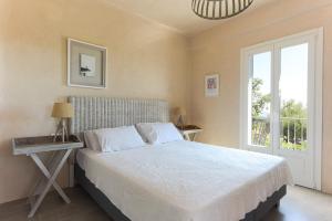 Luxurious Villa Nadoria, Ithaca Island في فاثي: غرفة نوم بسرير كبير ونافذة +70 صورة