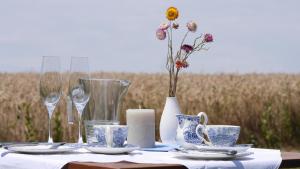 a table with blue and white plates and glasses and a vase at Gaestehaus Hofer in Bad Birnbach