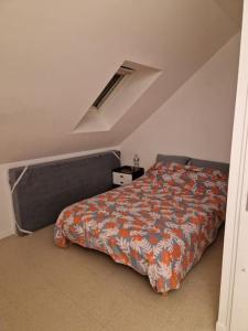 a bedroom with a bed with an orange comforter at Maison de ville près des jeux olympiques de Paris in Rueil-Malmaison