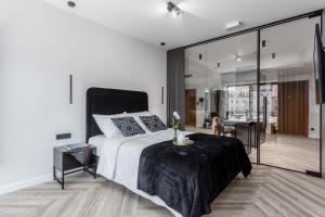 a bedroom with a large bed and a living room at DEO PLAZA - Apartments at the Old Town in Gdańsk