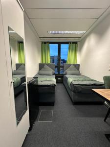 a small room with two beds and a mirror at Pension Bavaria Immobilien in Nuremberg