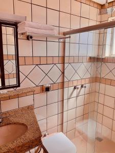 uma casa de banho com um chuveiro, um WC e um lavatório. em Victoria Plaza Hotel em Palmas