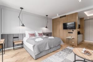 a bedroom with a bed and a flat screen tv at DEO PLAZA - Apartments at the Old Town in Gdańsk
