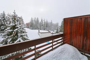a snowy yard with a fence and a snow covered tree at Joli studio avec parking gratuit in Crans-Montana
