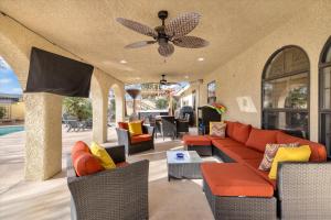 a living room with a couch and chairs and a ceiling fan at Ranch style villa with pool and spa in Las Vegas