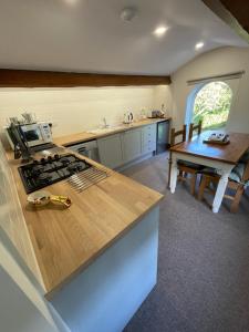 a kitchen with a stove and a table and a counter at Pear Tree House 2 bed apartment in Hartford