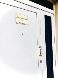a white garage door with a sign on it at Come a casa tua in Falconara Marittima