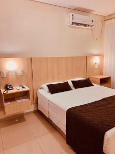 um quarto com uma cama grande e ar condicionado em Victoria Plaza Hotel em Palmas