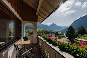einen Balkon mit einem Tisch, Stühlen und Blumen in der Unterkunft Haus Platina in Sankt Gallenkirch