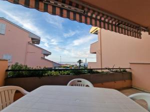 a table and chairs on the balcony of a building at Appartamento a 20mt dal mare con piscina condominiale in Marcelli