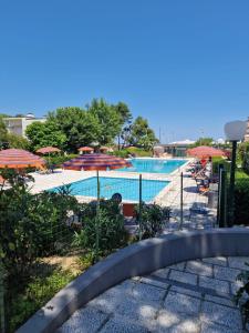 a view of a swimming pool with umbrellas at Appartamento a 20mt dal mare con piscina condominiale in Marcelli