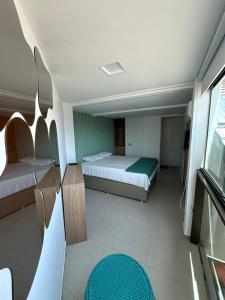 a small room with a bed and a window at SUNNY HALL, FLAT COM TRÊS QUARTOS in Porto De Galinhas