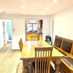 comedor con mesa de madera y sillas en Inviting 4-Bed House in Finchley London, en Hendon