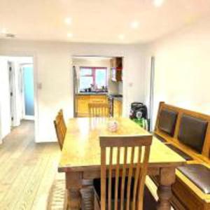 uma sala de jantar com uma mesa de madeira e cadeiras em Inviting 4-Bed House in Finchley London em Hendon