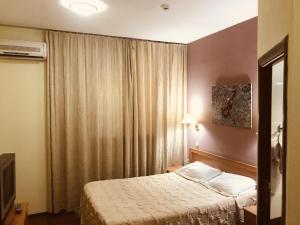 a hotel room with a bed and a window at Green Hotel in Atyraū