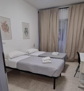 two beds in a small room with a window at Appartamento Caracas in Rome