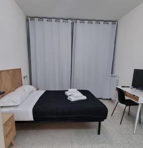 1 dormitorio con 1 cama con 2 toallas en Appartamento Caracas en Roma