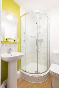 uma casa de banho com um chuveiro e um lavatório. em The County Hotel em Llandudno