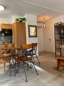 uma cozinha e sala de jantar com mesa e cadeiras em GRIMAUD Vue piscine em Grimaud
