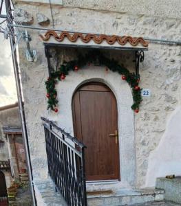 a building with a door with a christmas wreath at la casa nella roccia in Scontrone