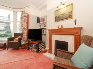 een woonkamer met een open haard en een televisie bij The Roses in Windermere