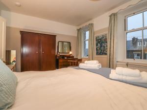 een slaapkamer met een groot bed met witte lakens bij The Roses in Windermere