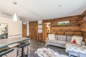 eine Küche und ein Wohnzimmer mit einer Holzwand in der Unterkunft Villa Princesse - Centre-ville - Renove in Chamonix-Mont-Blanc