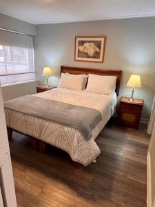 ein Schlafzimmer mit einem großen Bett mit zwei Nachttischen in der Unterkunft Isabel Suites Vitacura in Santiago