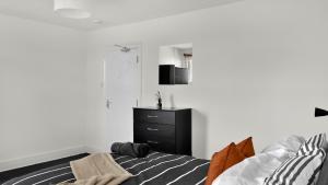 um quarto com uma cama e uma cómoda preta em 4 Bed 2 Bath House with Private Garden em Londres