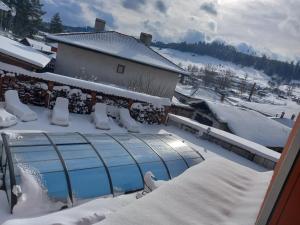 basen pokryty śniegiem na domu w obiekcie Kъща за гости Демария w mieście Kopriwsztica