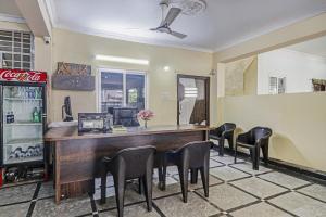 a restaurant with a bar with chairs and a soda machine at Super Hotel O Honey Heights Near Botanical Garden in Kondapur