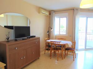 a dining room with a table and a television on a dresser at Terrasol Pirámides Puerto Blanco in Caleta De Velez