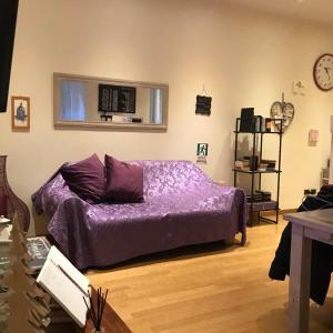 a living room with a purple bed and a table at Roma Da Noi Suite in Rome