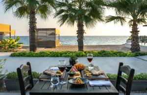 una mesa de madera con comida y vino en la playa en Paloma Orenda, en Side