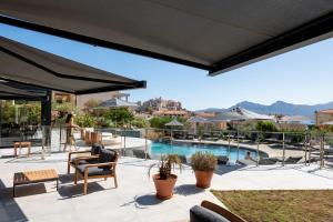 an outdoor patio with a view of a swimming pool at Hotel L'Acquale in Calvi