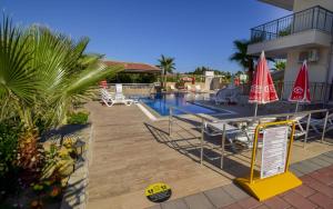 a resort with a swimming pool with a sign next to it at Esmeralda Butik Hotel in Kızılot