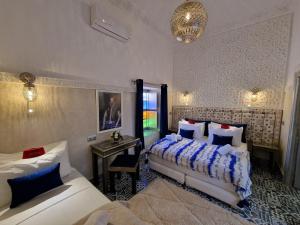 a bedroom with two beds and a table with a mirror at Riad Explore in Marrakesh